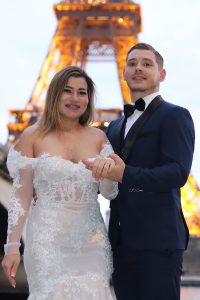 Couple in wedding attire in front of the eiffel tower